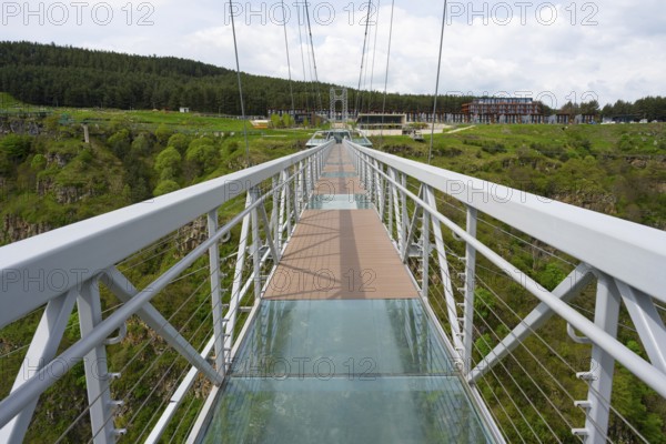 A modern suspension bridge with glass floor over a green landscape with forest, diamond bridge, Diamond Glass Bridge, world's longest free-hanging structure, Dashbashi Gorge, Khrami River, Chrami, Tsalka Nature Reserve, Kartli, Georgia