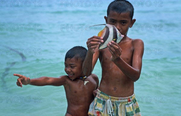 Two boys with a tropical fish on Ko Phi Phi Don, two years in front of the tsunami, Thailand, December 2002, vintage, retro, old, historic