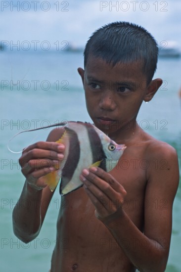 Boy with a tropical fish on Ko Phi Phi Don, two years in front of the tsunami, Thailand, December 2002, vintage, retro, old, historic