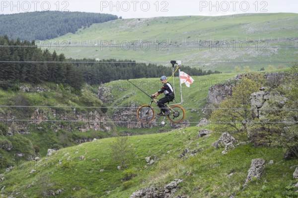 Cycling on a stretched rope across a hilly landscape with trees, Dashbashi Gorge, Khrami River, Tsalka Nature Reserve, Kartli, Georgia