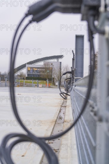 View of a building with solar panels and charging cable in the foreground, parking garage construction with charging infrastructure, Calw, Germany
