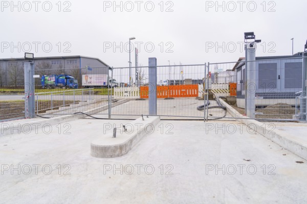 Closed construction site with concrete floor in an industrial environment, parking garage construction with charging infrastructure, Calw, Germany