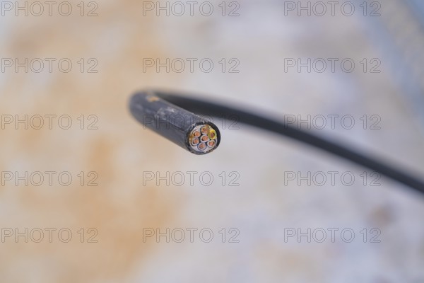 Close-up of a cut cable with visible wires, parking garage construction with charging infrastructure, Calw, Germany