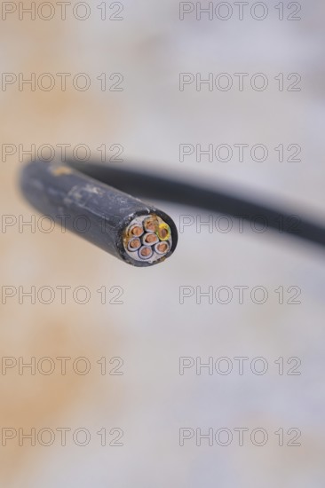 Sharp close-up of an electrical cable with multiple wires, parking garage construction with charging infrastructure, Calw, Germany