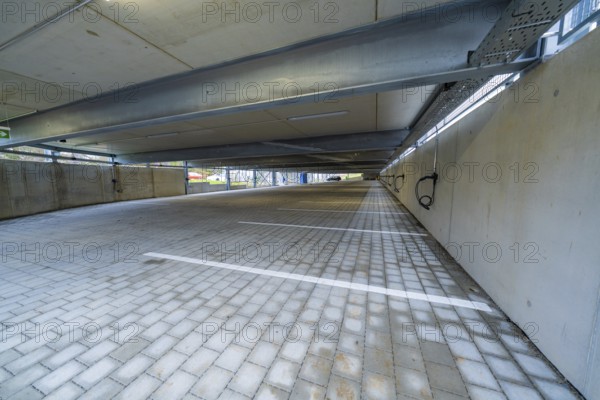 Empty covered parking lot with concrete structure and marked parking spaces, parking garage construction with charging infrastructure, Calw, Germany