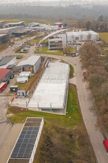 Aerial view of an industrial area with buildings and parking spaces, parking garage construction with charging infrastructure, Calw, Germany