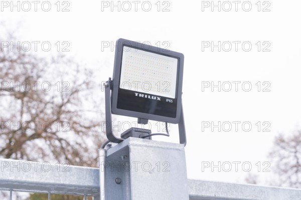 A Trilux LED lamp is mounted on a metal post, with cloudy sky, parking garage construction with charging infrastructure, Calw, Germany