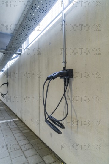 Electric charging station mounted on a concrete wall in a parking garage, parking garage construction with charging infrastructure, Calw, Germany