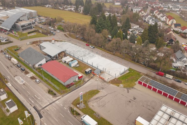 Urban environment seen from above with parking lots and roads in winter, parking garage construction with charging infrastructure, Calw, Germany