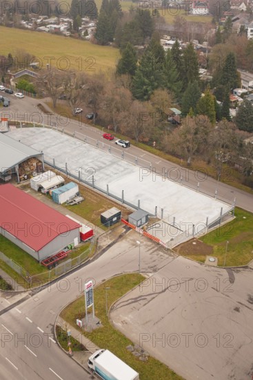 Urban aerial view with parking lot, roads and surrounding buildings, parking garage construction with charging infrastructure, Calw, Germany