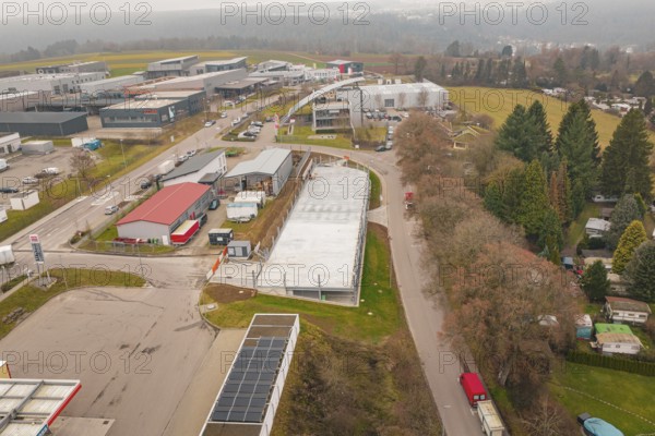 View from above of an urban environment with roads and buildings in winter, parking garage construction with charging infrastructure, Calw, Germany