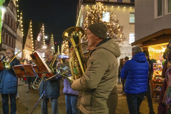 Brass players play at a Christmas market with festive lighting, Weihnachtsmark Nagold, LandkreisCalw, Germany
