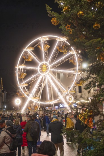 Lights of a Ferris wheel structure in the midst of a crowd at a Christmas market, Weihnachtsmark Nagold, LandkreisCalw, Germany