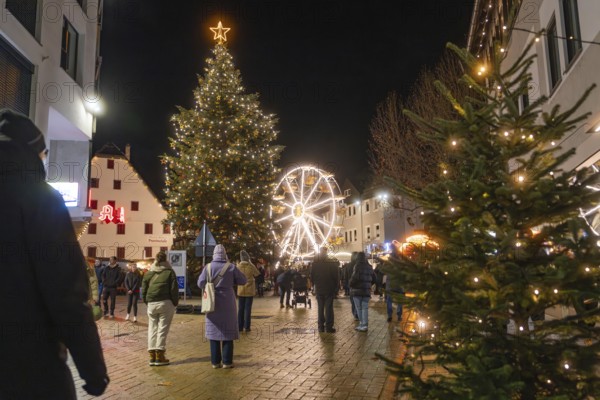 Illuminated Christmas tree and Ferris wheel in a festively decorated city at night, Weihnachtsmark Nagold, LandkreiScalw, Germany