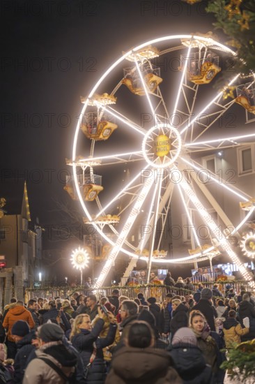 Large illuminated Ferris wheel surrounded by crowds at a Christmas market, Weihnachtsmark Nagold, LandkreisCalw, Germany