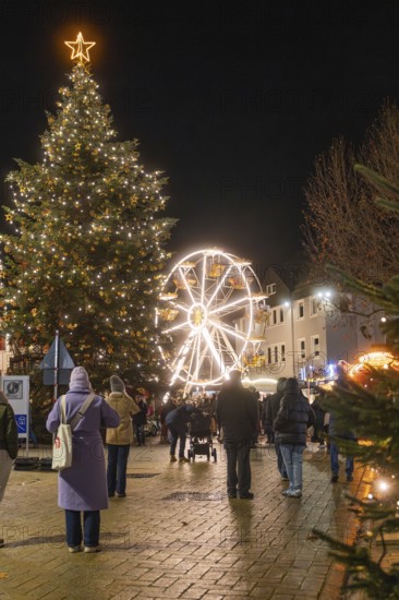 Christmassy tree and Ferris wheel in a busy city at night, Weihnachtsmark Nagold, LandkreiScalw, Germany