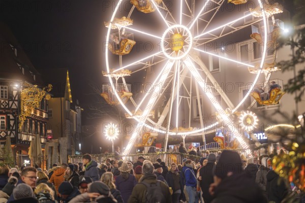 Large illuminated Ferris wheel next to a crowd at a Christmas market at night, Weihnachtsmark Nagold, LandkreiScalw, Germany