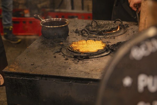 Waffles are freshly prepared on a hot oven at a market stand, Weihnachtsmark Nagold, LandkreiScalw, Germany