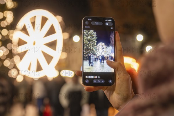 A Ferris wheel and a tree at a Christmas market are photographed with a smartphone, Weihnachtsmark Nagold, LandkreisCalw, Germany