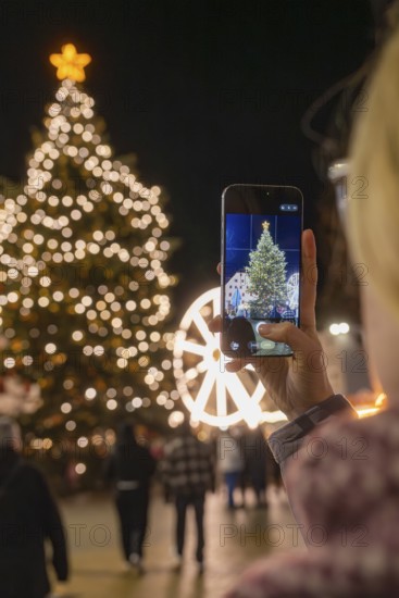 An illuminated tree at a Christmas market is captured with a smartphone, Weihnachtsmark Nagold, LandkreisCalw, Germany
