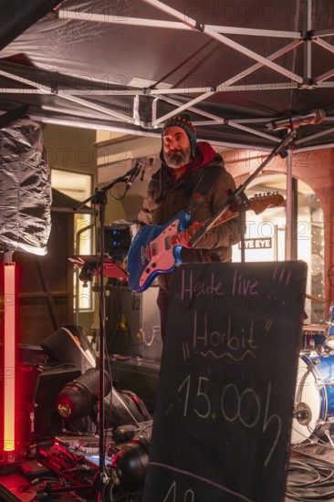 Guitarist performing live at night under a pavilion, Weihnachtsmark Nagold, LandkreisCalw, Germany