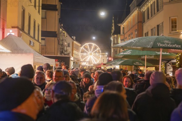 Busy night market with illuminated Ferris wheel in urban surroundings, Weihnachtsmark Nagold, LandkreiScalw, Germany