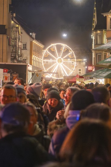 Night market with crowd and glowing Ferris wheel in the background, Weihnachtsmark Nagold, LandkreiScalw, Germany