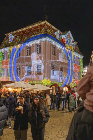 Artistic light projection onto a building at night, surrounded by people and a festive atmosphere, Weihnachtsmark Nagold, LandkreisCalw, Germany