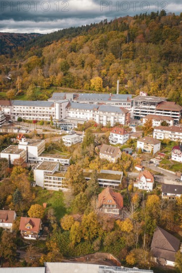 Autumn city view with buildings and trees in hilly landscape under cloudy sky, Altes Krankenhaus, Calw, Germany