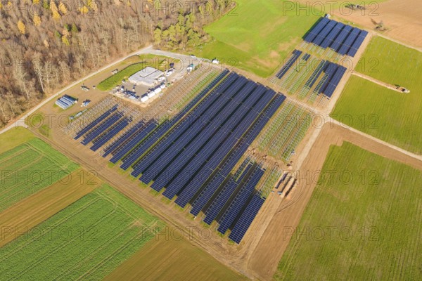 Extensive solar system surrounded by green fields, surrounded by autumn trees, energy revolution, construction of PV open space, Baden-Württemberg, Germany
