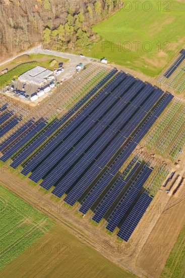 Large solar park right on the edge of an autumn forest and green fields, energy revolution, construction of PV open space, Baden-Württemberg, Germany