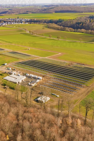 Large solar system next to buildings, surrounded by fields and forests, energy revolution, construction of PV open space, Baden-Württemberg, Germany