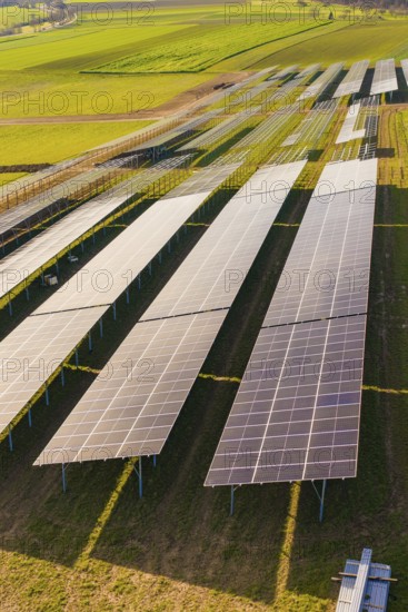 Close-up of solar cells on green fields under bright sky, Energiewende, construction of PV open space, Baden-Württemberg, Germany