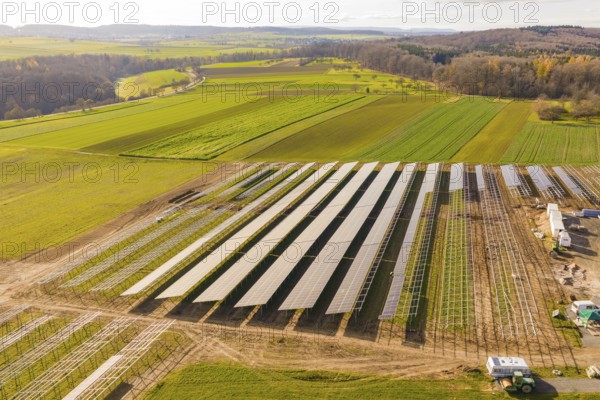 Solar panels on a field in a hilly landscape under sunny sky, Energiewende, construction of PV open space, Baden-Württemberg, Germany