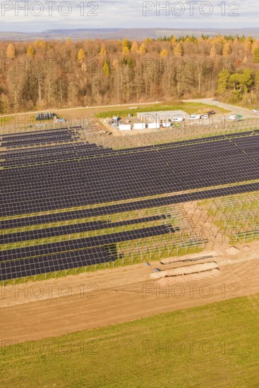 Large solar fields next to a forest area in autumn, energy revolution, construction of PV open space, Baden-Württemberg, Germany