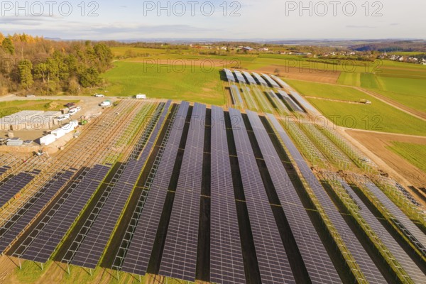 Large solar field surrounded by green fields and hills, sunny atmosphere, energy revolution, construction of PV open space, Baden-Württemberg, Germany