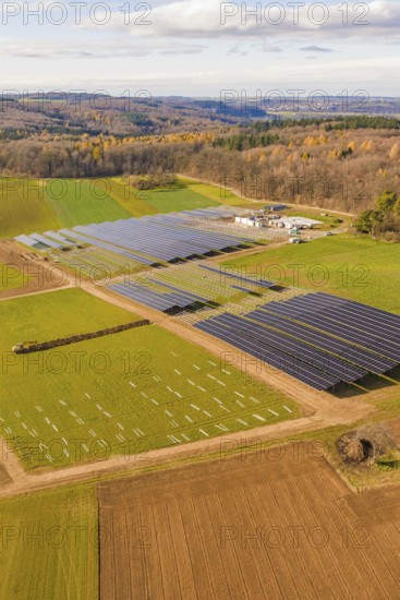 Aerial view of a solar park surrounded by fields and autumn forests, energy revolution, construction of PV open space, Baden-Württemberg, Germany