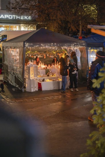 Atmospheric Christmas market stand with winter decorations and visitors at night, Christmas market, Aidingen, Germany