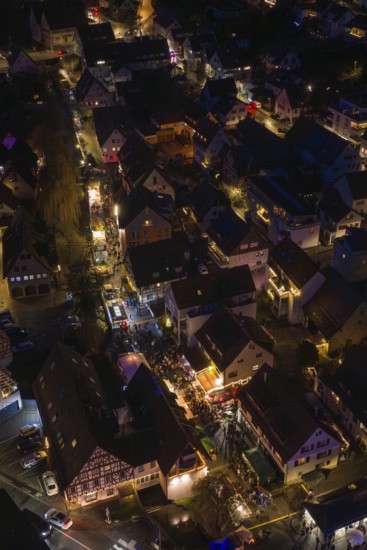 Aerial view of illuminated city at night with busy streets and festive atmosphere, Christmas market, Aidingen, Germany