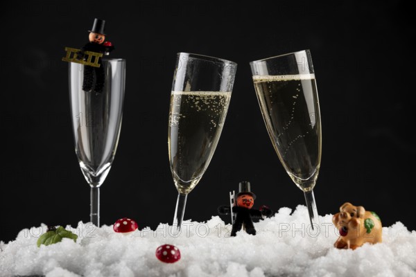 Champagne glasses filled with lucky charms for New Year in the snow