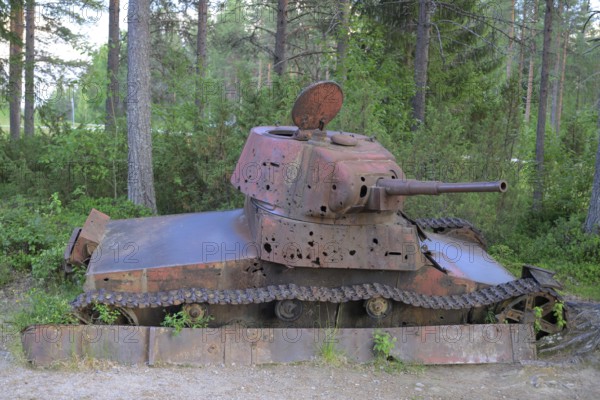 Rusted tank in the forest with visible signs of age and vegetation, museum at the Winter War Memorial, near Suomussalmi, Winter War 1939-1940, Winter War Memorial, Finland