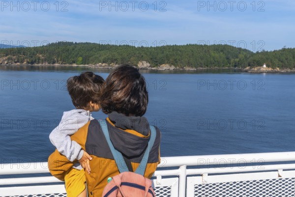 Mother and child enjoying the scenic ocean view from a ferry deck on the journey from victoria to vancouver, creating a heartwarming family travel moment