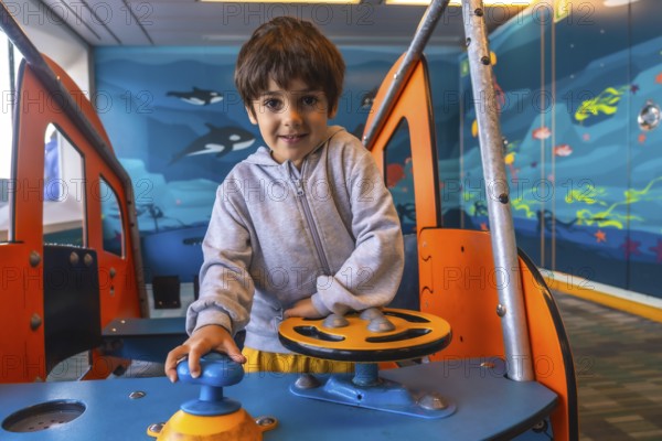 Young boy enjoying playing captain on a ferry boat traveling from victoria, vancouver island, to vancouver, british columbia, navigating imaginary waters with a playful smile
