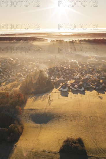 Landscape with settlement in fog at sunrise and slightly snow-covered fields, Gechingen, Calw district, Germany