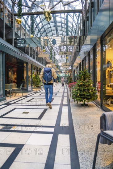 Person in modern shopping arcade with Christmas decoration and festive atmosphere, Calwer Passage, Stuttgart, Germany
