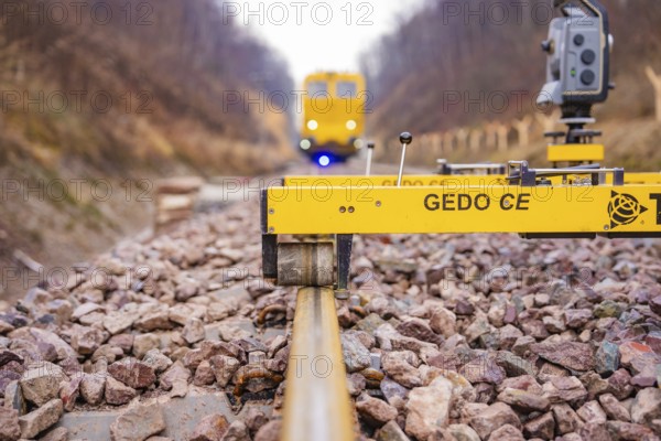 A Gedo CE device on rails with a yellow vehicle in the background, tamping machine on Hermann, Hesse, Bahn, Althengstett, Calw district, Germany