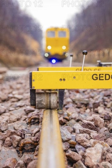 Close-up of a rail surveyor, a yellow vehicle in the background, tamping machine on the Hermann, Hesse, railway, Althengstett, Calw district, Germany