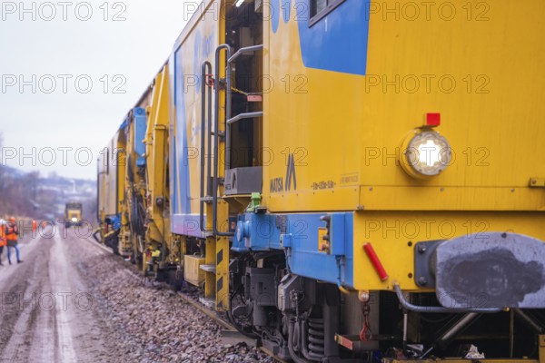 Several yellow work trains run along a rail route to maintenance, tamping machine on Hermann, Hesse, Bahn, Althengstett, Calw district, Germany