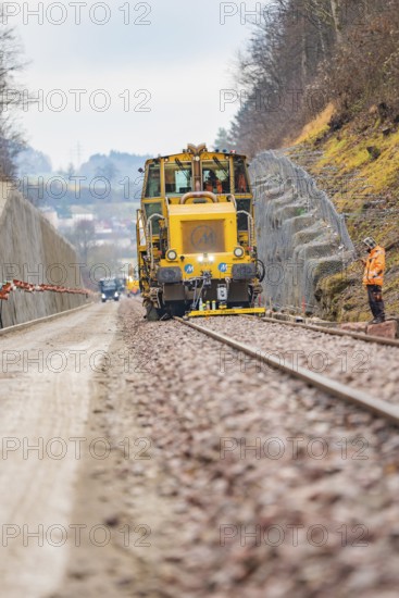 Machine and worker on rails during construction work in a rural area, tamping machine on Hermann, Hesse, railway, Althengstett, Calw district, Germany