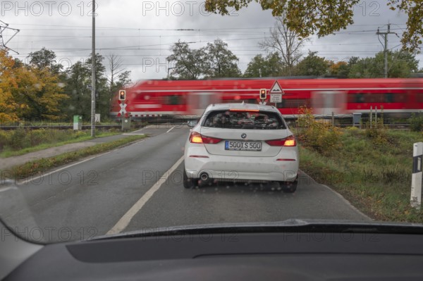 Regional train crosses a restricted level crossing, cars waiting in front of it, Fürth Mittelfranken, Bavaria, Germany